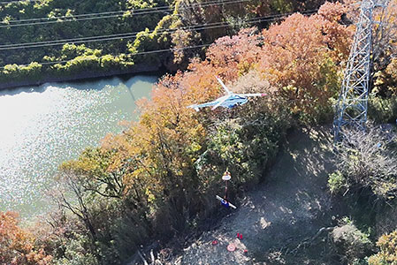 （右）送電鉄塔の近くで荷降ろしする様子